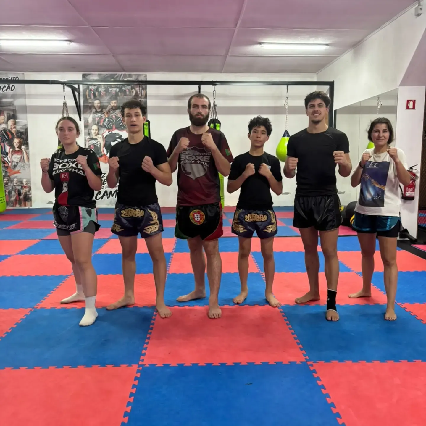 Seis atletas da VH Team Fighters em guarda no tatame vermelho e azul, depois de um treino de competição